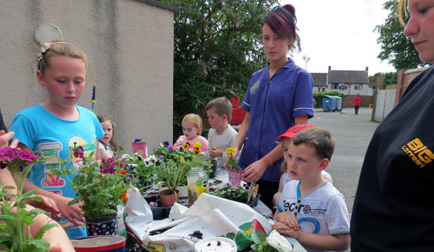 Children learning gardening skills with the team