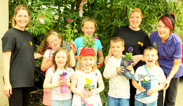 Children learning gardening skills with the team